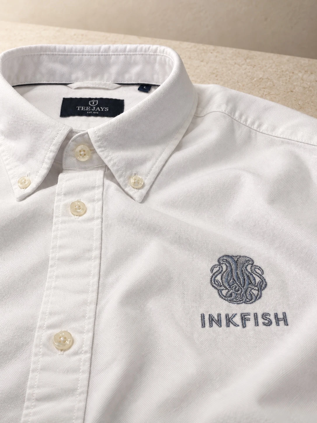 Camisa blanca de botones con el nombre y emblema de Inkfish bordados